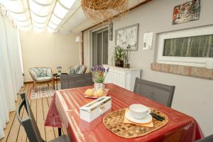 a dining room with a red table and chairs at Ancora Apartments in Marina di Massa