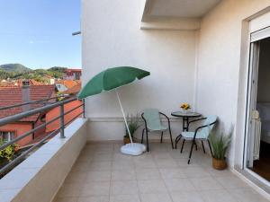 a balcony with a table and chairs and an umbrella at Prizma in Cetinje +4 photos