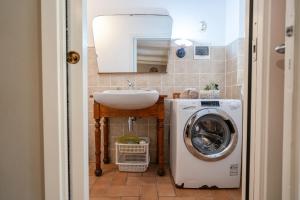 a bathroom with a sink and a washing machine at Ancora Apartments in Marina di Massa