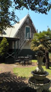 uma casa com uma fonte em frente a um edifício em A Pilgrims Rest em Graskop