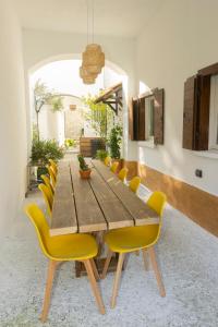 a dining room with a wooden table and yellow chairs at Monastero Retreat - Villa con SPA in Lanzo dʼIntelvi