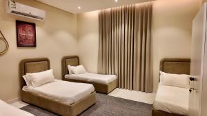 a small room with two beds and a window at نزل ليلى الفندقية الفاخرة luxury in Abha +123 photos