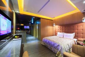 a hotel room with a bed and a flat screen tv at 華倫汽車旅館 in Erlin