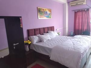 a bedroom with a large bed with purple walls at Hotel madhav regency bhopal in Misrod +10 photos