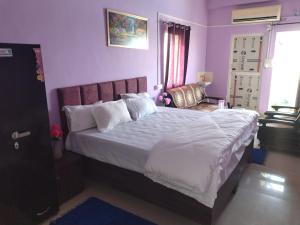 a bedroom with a large bed with white sheets and pillows at Hotel madhav regency bhopal in Misrod