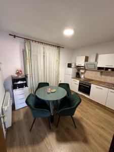 a living room with a table and chairs and a kitchen at Apartment & Apartment Studio Deželjin in Senj