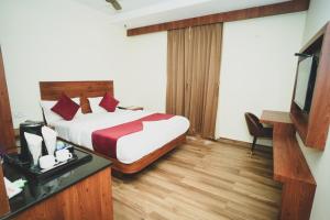 a hotel room with a bed and a television at S K Legacy Hotel in Mysore