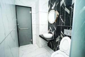 a bathroom with a toilet and a sink and a mirror at S K Legacy Hotel in Mysore +8 photos