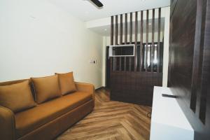 a living room with a couch and a tv at S K Legacy Hotel in Mysore
