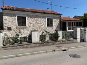 a brick house with a fence in front of a street at Danilo Room 1 in Pula