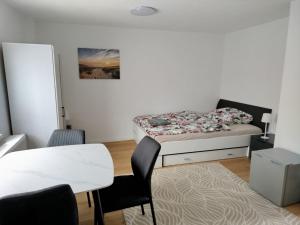 a bedroom with a bed and a table and chairs at Ferienwohnung Schießstatt in Bad Saulgau