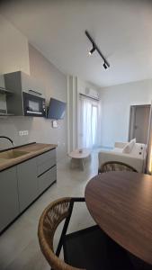 a kitchen and living room with a table and a couch at Inos Boutique Apartments in Skala Prinou