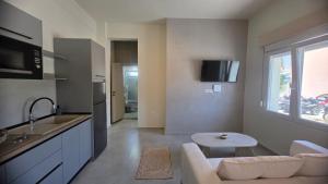 a kitchen and living room with a couch and a table at Inos Boutique Apartments in Skala Prinou +40 photos