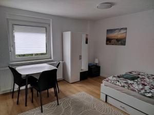 a bedroom with a bed and a desk and a table at Ferienwohnung Schießstatt in Bad Saulgau