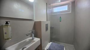 a white bathroom with a sink and a shower at Inos Boutique Apartments in Skala Prinou
