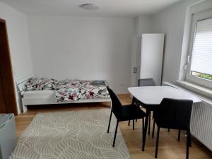 a bedroom with a bed and a table and chairs at Ferienwohnung Schießstatt in Bad Saulgau
