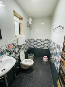 a bathroom with a toilet and a sink at Vaidic Yoga Retreat in Ponsuli
