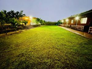 a large grassy yard with a building and lights at Vaidic Yoga Retreat in Ponsuli