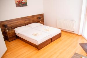 a bedroom with a bed with a wooden headboard at Mliečna víla in Turčianske Teplice +4 photos