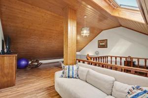 a living room with a couch and wooden walls at Casa Na Aldeia in Arões