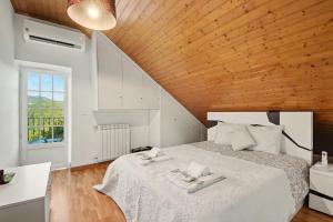 a bedroom with a white bed with a wooden ceiling at Casa Na Aldeia in Arões +27 photos