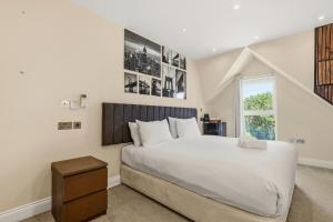 a bedroom with a large white bed and a window at London Star Hotel in London