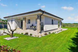 a small white house with a green lawn at Villa Tea by Rent Istria in Umag