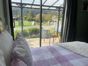 a bedroom with a bed and a view of a patio at Robbies Hut in Greymouth