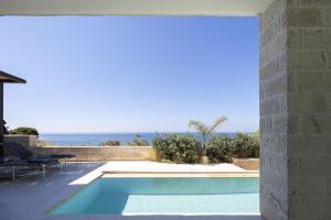 a swimming pool with a view of the ocean at My Cave Blue Iconic Designer Villa by etouri in Rethymno +43 photos