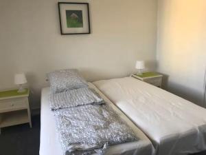 a bedroom with a bed with two nightstands and two tables at Svanegade 1 , 2 sal in Thyborøn