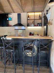 a kitchen with a bar with black stools at Villa Jalan in Vrsi