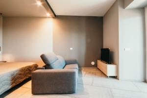 a bedroom with a bed and a chair and a tv at Appartamento Meda - Lakeside Leisure & Business in Cissano +25 photos