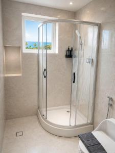 a shower stall in a bathroom with a window at Asteria Ocean Residence in Danang