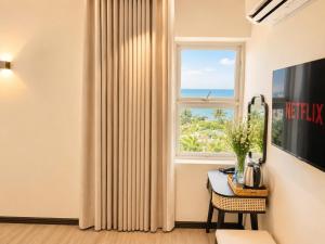 a living room with a window and a table with a table at Asteria Ocean Residence in Danang