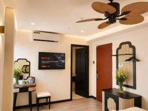 a living room with a ceiling fan and a door at Asteria Ocean Residence in Danang +24 photos