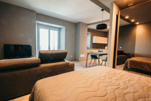 a bedroom with a bed and a tv and a couch at Appartamento Meda - Lakeside Leisure & Business in Cissano