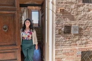 a woman standing in the doorway of a building at Hotel Oviv - La dimora del Borgo in Acquaviva Picena