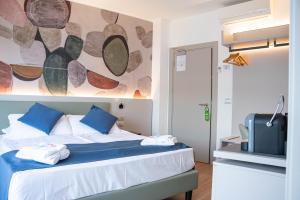 a bedroom with a bed with a painting on the wall at Hotel Casa Marinella in Malcesine +137 photos