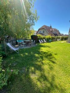 ein Garten mit einem Picknicktisch und Stühlen im Gras in der Unterkunft Dom Wakacyjny Karol in Łeba