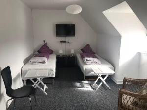 a room with two beds and a chair in it at Svanegade 1 , 2 sal in Thyborøn