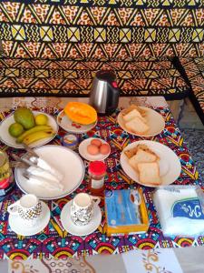 a table with plates of bread and fruit on it at Arham Nungwi Beach in Nungwi
