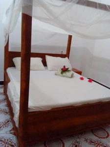 a wooden bed with flowers on top of it at Arham Nungwi Beach in Nungwi
