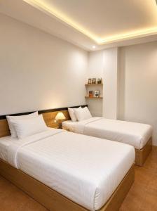 two beds in a room with white walls at Awesome Hanoi Hostel & Travel in Hanoi +83 photos