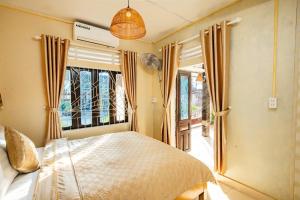 a bedroom with a bed and a large window at Di Mo homestay Citadel Conner in Thôn Kim Long (1)