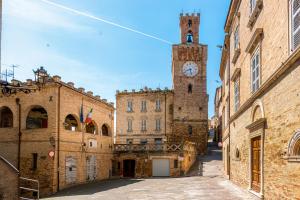 an alley with a clock tower in an old building at Hotel Oviv - La dimora del Borgo in Acquaviva Picena