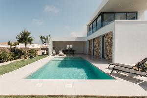 a swimming pool in the backyard of a house at Canalola in Cala en Bosc