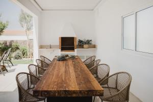a dining room with a wooden table and chairs at Canalola in Cala en Bosc
