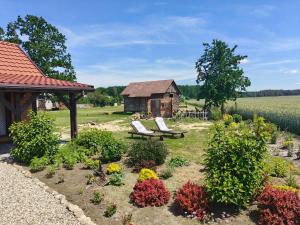 a garden with two chairs and a gazebo and flowers at Słoneczne Łąki in Wólka Soseńska