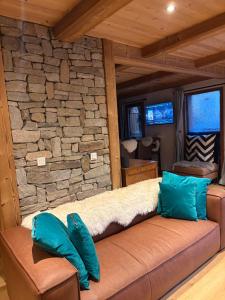 a couch in a room with a stone wall at Chalet Beaufort in Saint-Martin-de-Belleville