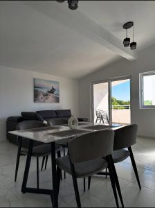 a dining room with a table and chairs and a couch at Martin Apartments in Gornji Štoj